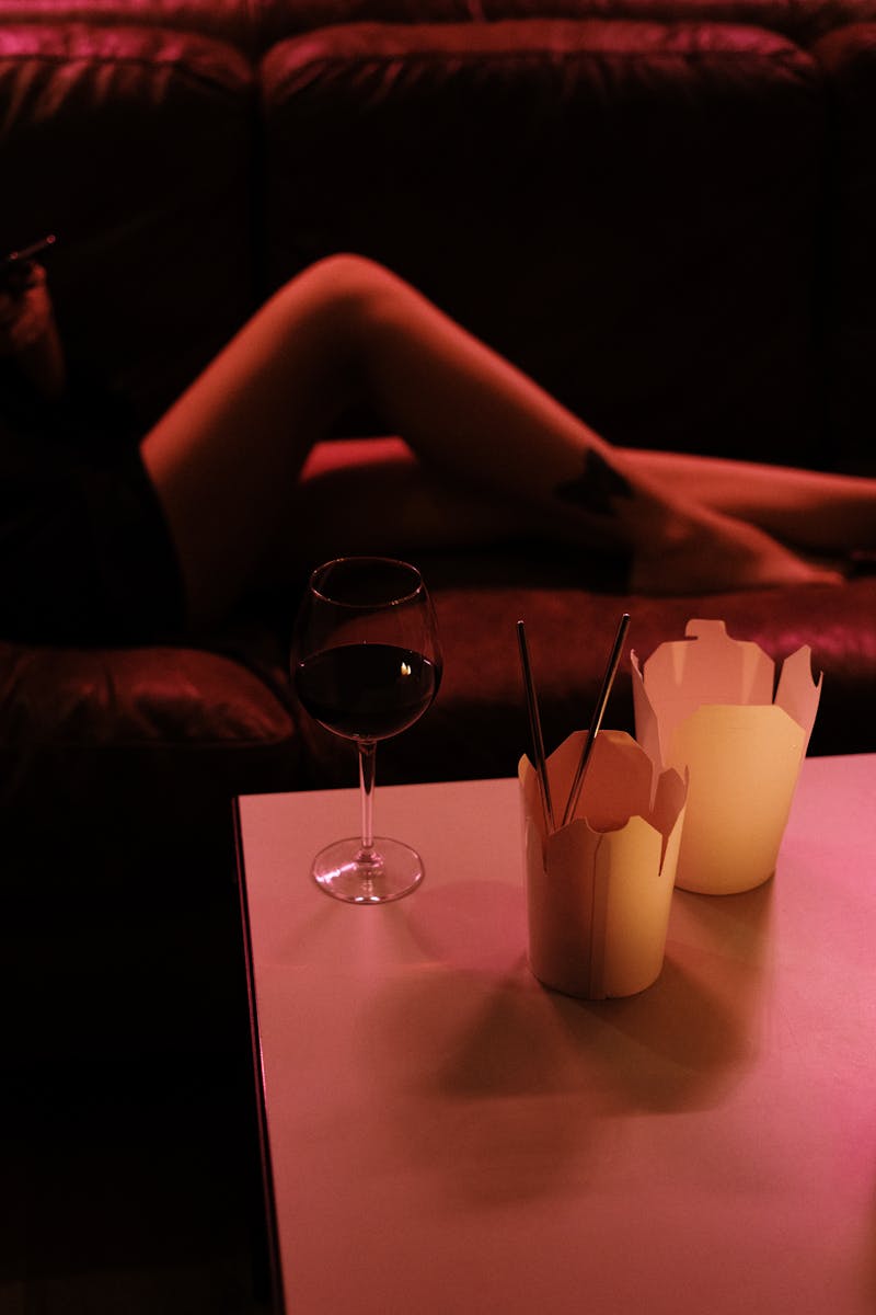 A relaxing indoor scene featuring wine and takeout under warm lighting.